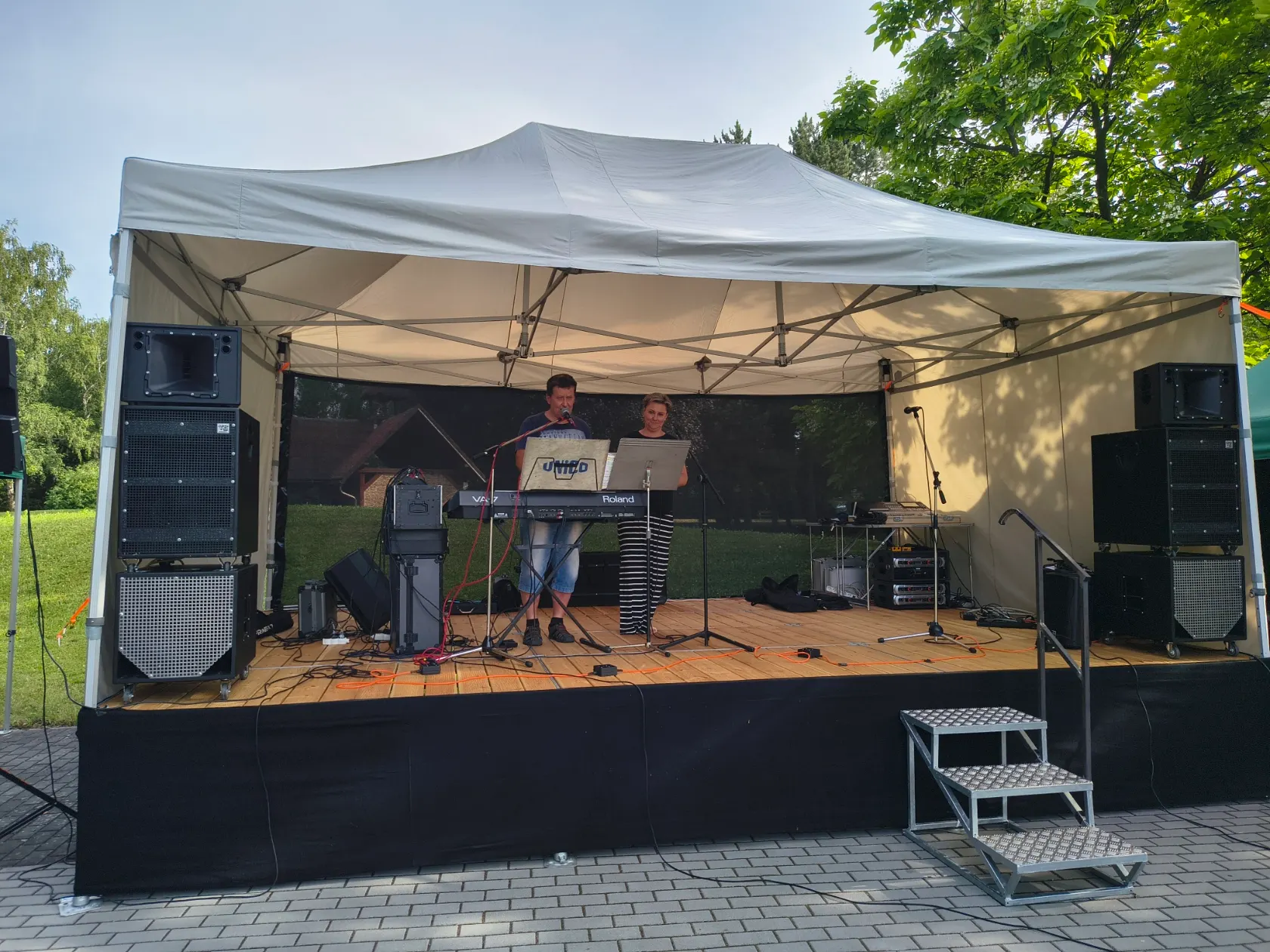 Hudebníci hrají na pódiu, celkový pohled na scénu